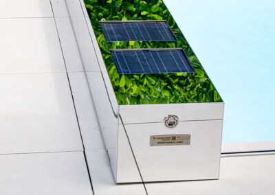 Coverseal-landscape8 Plan rapproché du coffre miroir Coverseal, sur lequel sont intégrés deux panneaux solaires, reflétant la végétation alentour.